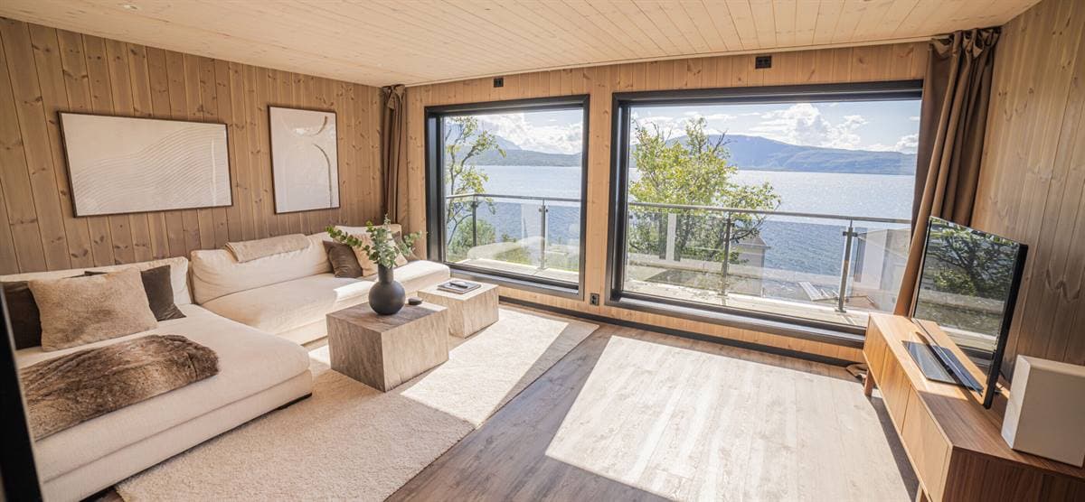 Vardagsrum med vit soffa och panoramafönster