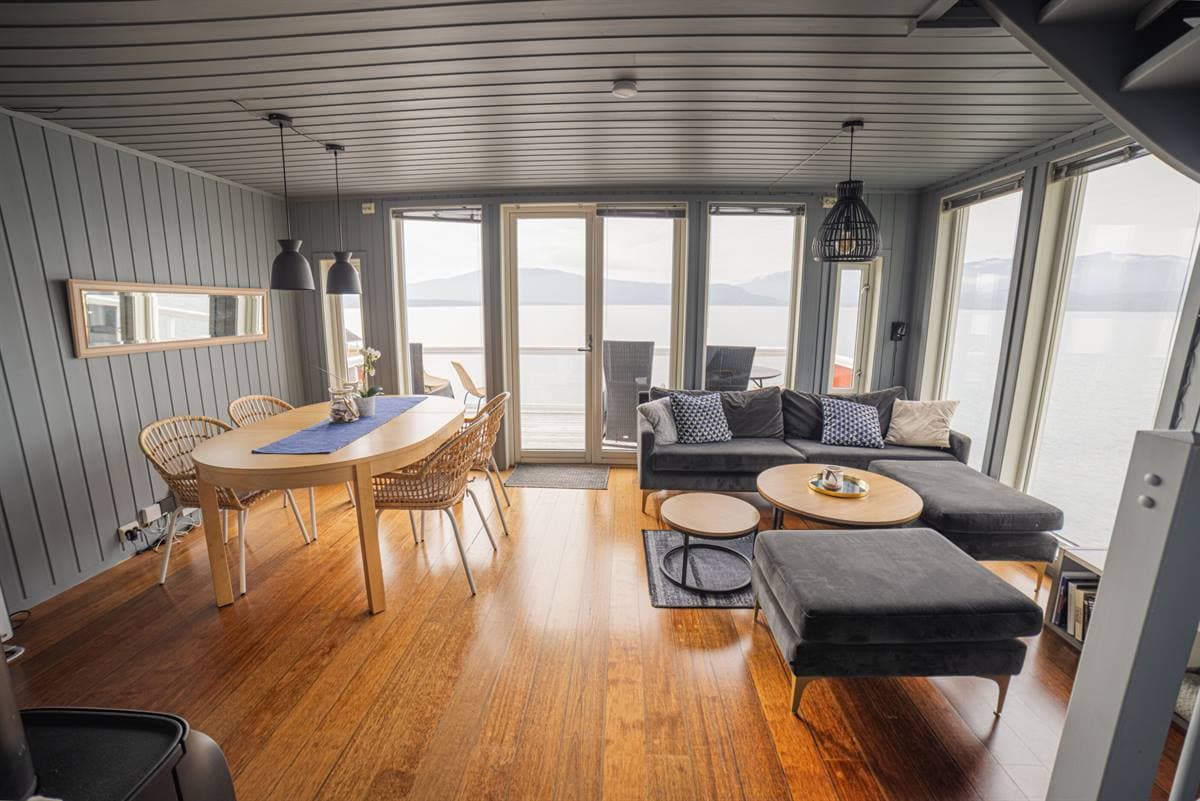 Vardagsrum med matbord och fjordutsikt