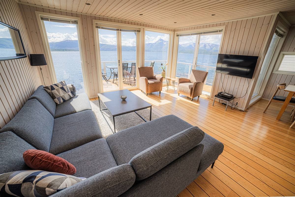 Vardagsrum med grå soffa och fjordutsikt