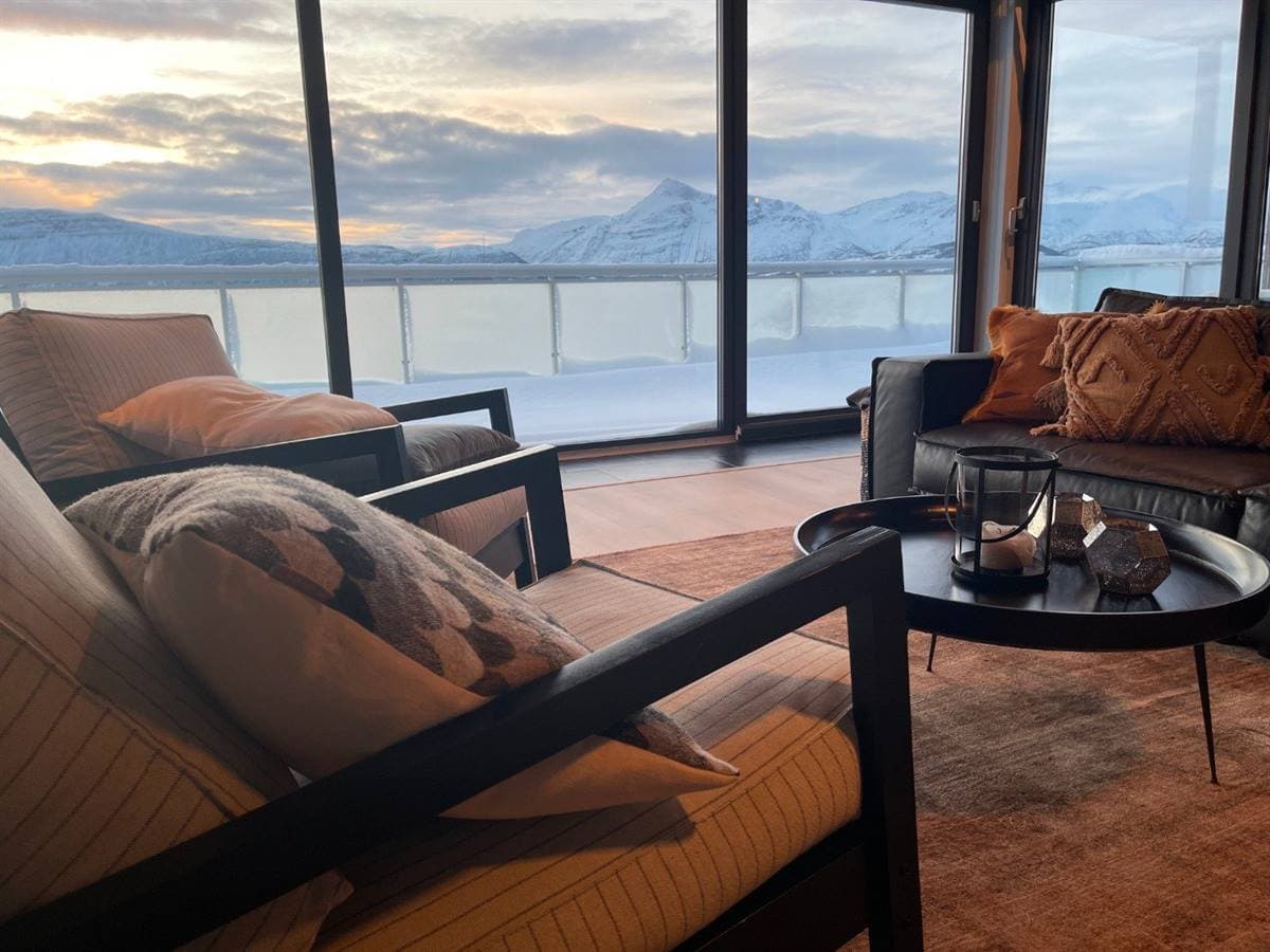 Sittgrupp i vardagsrummet med utsikt över den snöklädda fjorden